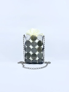 Macro view of metallic sequins and cream drawstring inner bag on a mini bucket bag