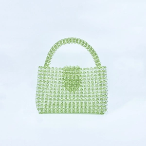 Detail view of handmade green acrylic beaded tote bag featuring a subtle heart pattern weave