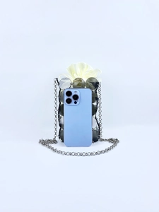 Black sequin mini crossbody bag showing size comparison with a smartphone