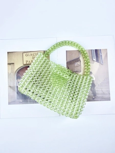 Macro detail of hand-woven light green acrylic beaded handbag with round handle