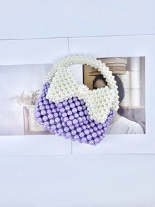 Dettaglio macro della mini borsa fatta a mano con perle viola e design a fiocco