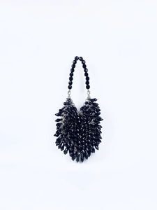 Close-up of black beaded handbag with faceted droplets and silver metal clasps