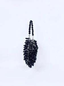 Detail of glossy black acrylic beaded tassel handbag with silver metal chain hardware