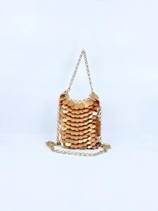 Detailed close-up of glittering gold sequin mini bag with delicate metal chain strap