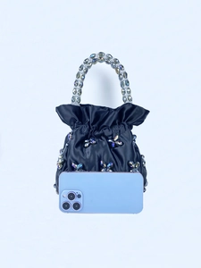 Detail of navy satin drawstring bucket bag with crystal floral beads and phone for scale