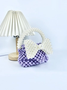Dettaglio della borsa in perline fatta a mano con un grande fiocco decorativo in perle