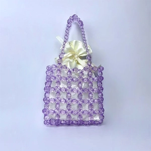 Close-up of purple beaded handbag with a creamy white satin drawstring inner pouch