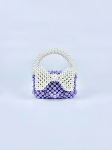 Dettaglio della mini borsa di perle fatta a mano con perle viola e fiocco di perle