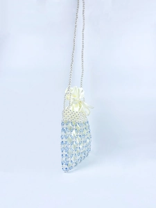 Detail of handcrafted beaded bag featuring blue crystals and white pearls texture