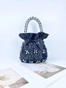 Detail of black satin bucket bag with iridescent crystal flower beads and beaded handle