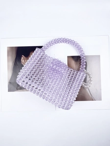 Detail of handmade purple acrylic beaded handbag with round handle and woven texture
