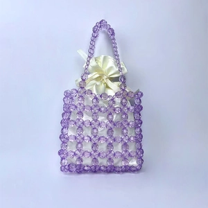 Detail of purple handmade beaded handbag with white satin drawstring inner pouch