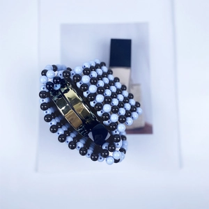 Détail du motif de perles bleues et noires fait main sur une pince à cheveux en métal doré