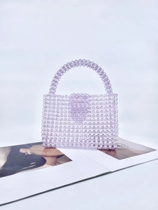 Detail of purple handmade acrylic beaded handbag on a fashion magazine background