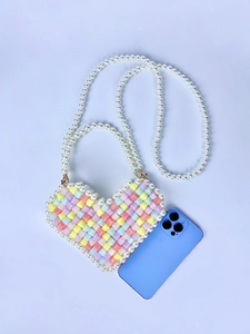 Macro detail of heart-shaped beaded mini bag with pastel colors and pearl strap