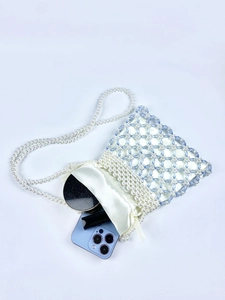 Detail of beaded pearls bag showing the handmade woven hollow structure and satin pouch