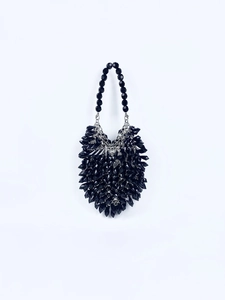 Detail of handmade black acrylic beaded handbag featuring faceted crystal-like texture
