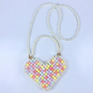 Detail view of heart-shaped beaded bag with colorful pastel beads and pearl shoulder strap