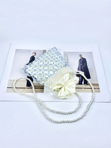 Detail of handmade woven pearl bead bag with light blue crystal beads and bow drawstring liner