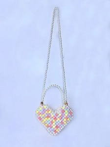 Macro detail of handmade heart-shaped beaded mini bag with pastel beads and pearl strap