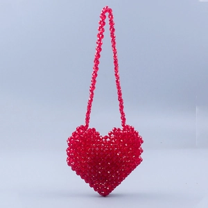 Detailed view of a handmade red heart-shaped beaded crossbody bag with acrylic crystals