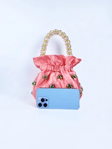 Detailed shot of pink satin drawstring handbag with green crystal beads and beaded handle