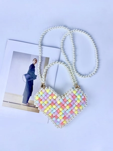 Macro detail of heart-shaped beaded mini bag with rainbow colors and pearl chain