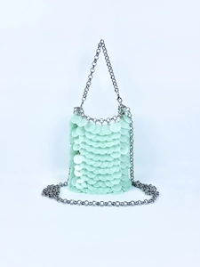 Macro shot of mint green sequins and silver chain strap on this stylish crossbody bag