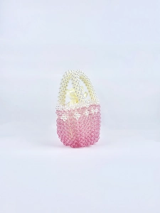 Detailed shot of pink beaded woven handbag with satin drawstring lining and bow detail