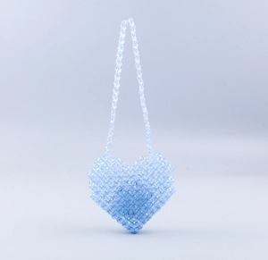 Detail of handmade light blue heart-shaped beaded bag with translucent pearls