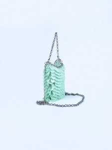 Detail of mint green sequin phone bag featuring a silver metal chain and fish scale texture