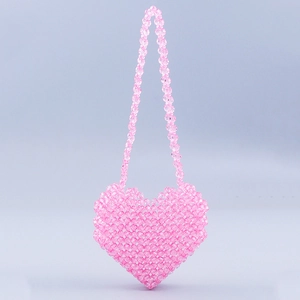 Detail of a pink heart-shaped handmade beaded crossbody bag with a long beaded shoulder strap