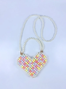 Macro detail of handmade heart-shaped beaded mini bag with colorful candy beads and pearls