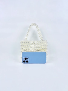 Mini pearl beaded handbag showing size comparison with a smartphone on plain background
