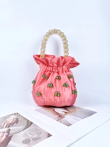 Detail of pink satin pouch bag featuring handmade green and white cherry beaded charms