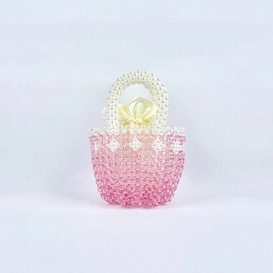 Detail of pink beaded handbag with pearl handle and satin interior with silk bow