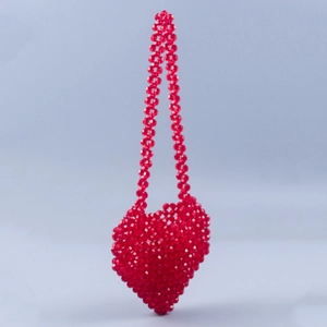 Detailed view of the handmade red heart-shaped beaded crossbody bag showing acrylic texture