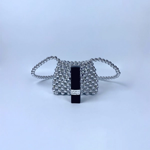 Mini silver beaded crossbody bag shown with a lipstick for size reference and scale