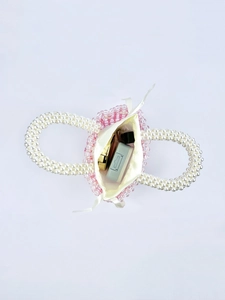 Detailed view of pink beaded handbag with pearl handle showing satin drawstring pouch interior