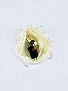 Top view of pearl beaded handbag showing satin lining and storage capacity for cosmetics