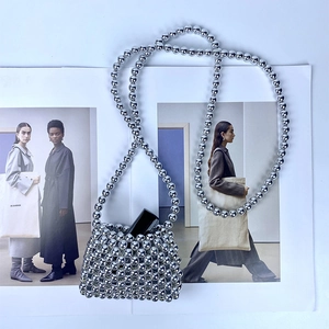 Mini silver beaded bag with long shoulder strap and a lipstick inside for scale