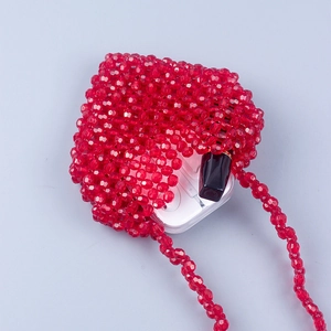 Macro detail of a red handmade beaded mini bag with translucent faceted acrylic beads