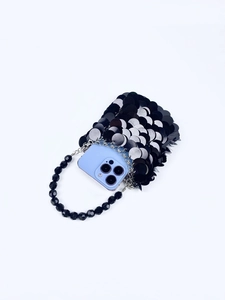 Détail du mini sac à paillettes noires montrant l'espace pour un smartphone
