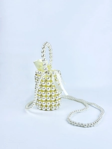 Detail of handmade pearl bucket bag with gold accents and satin drawstring inner lining