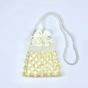 Detail of woven cream satin inner pouch and yellow faceted bead mesh on pearl bag