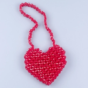 Macro view of a handmade red heart-shaped beaded mini bag with acrylic crystal texture