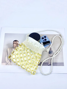 Detail of beaded crossbody bag showing handmade pearl mesh and yellow satin lining
