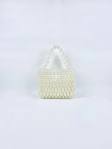 Detail of hand-woven pearl handbag featuring elegant white bead textures and vintage design