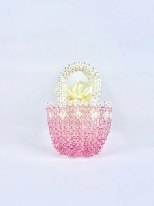 Detailed shot of handmade pink beaded handbag with pearl handle and yellow satin lining