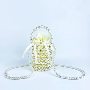 Detail view of woven pearl bucket bag with gold accents and cream satin drawstring liner